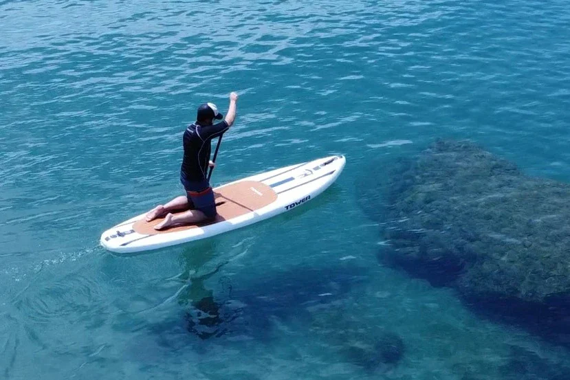 Testing Tower Paddle Board On Water While Kneeling